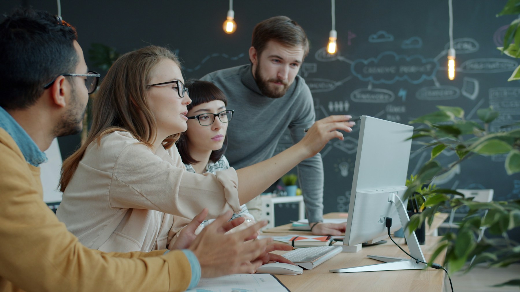 Coworkers gathered around a computer in an office